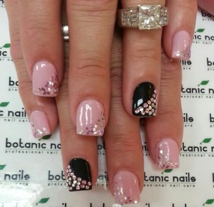 bling nail designs, two hands with short square nails, painted in pink and black, each decorated with rhinestones