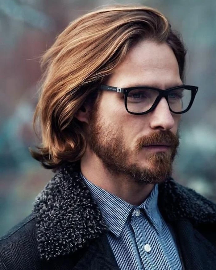 shoulder length hair, auburn haired man with glasses, mustache and beard, blue pinstriped shirt and coat