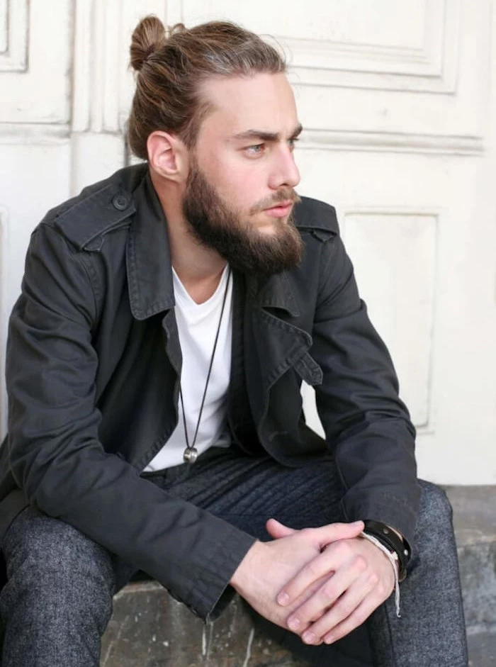 medium length hair, sitting dark blond man, hair tied in a man bun, mid-length beard and mustache
