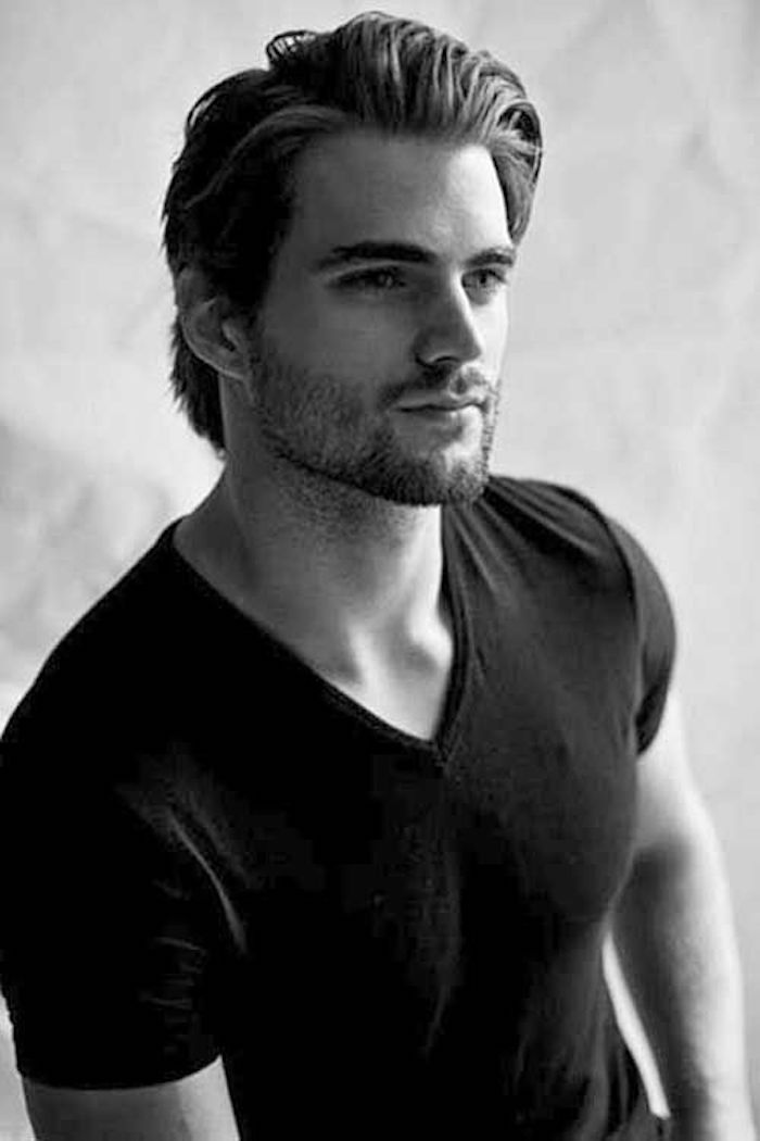 hairstyles for medium length hair, smiling man in black t-shirt, stubble beard and mustache, dark hair parted to one side and slicked back