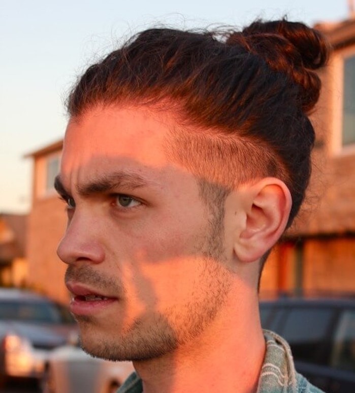 hairstyles for shoulder length hair, serious looking man, with stubble beard and mustache, short undercut and man bun