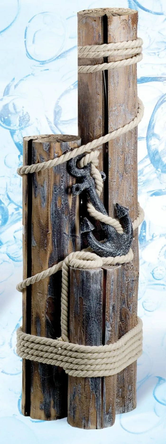 summer crafts, wooden decoration made from three pieces of rough wood, in different sizes, tied together with rope, and featuring a metal anchor element