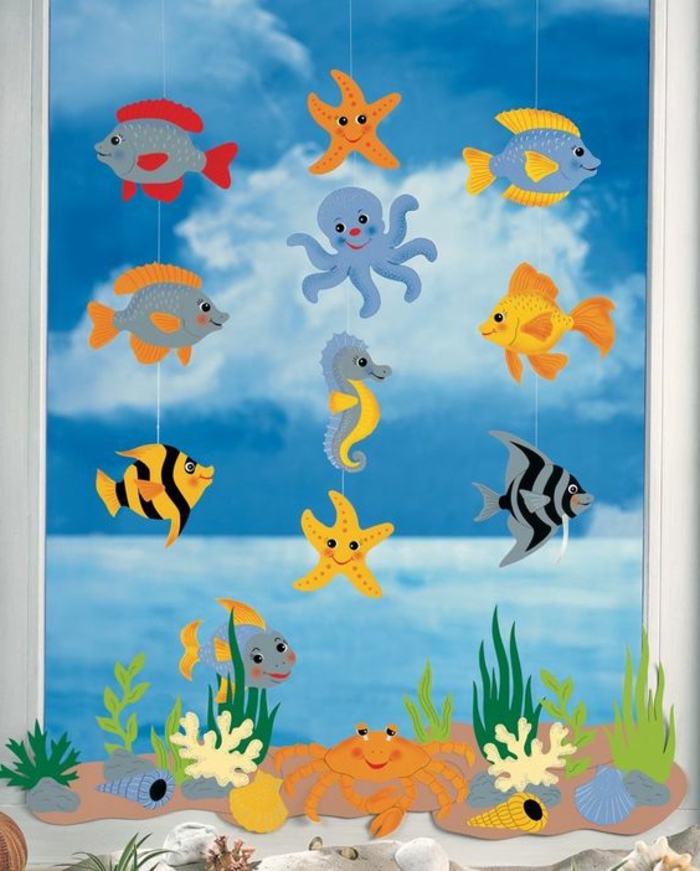 easy fun diys, decoration made from several paper cutouts, shaped like cartoon-fish and sea animals, hanging from white peaces of thread, cartoon underwater picture in background