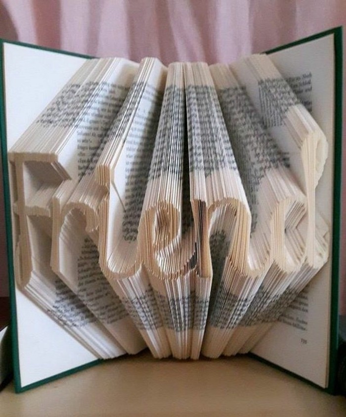the word friend, created from folded pages, inside an open book, with hard green and white covers