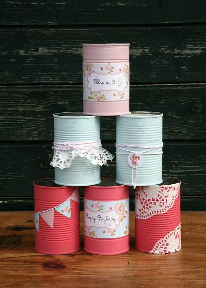 aluminum tins, six cans stacked in a pyramid, colored in salmon pink, light blue and pastel pink, decorated with string, floral paper and white doilies