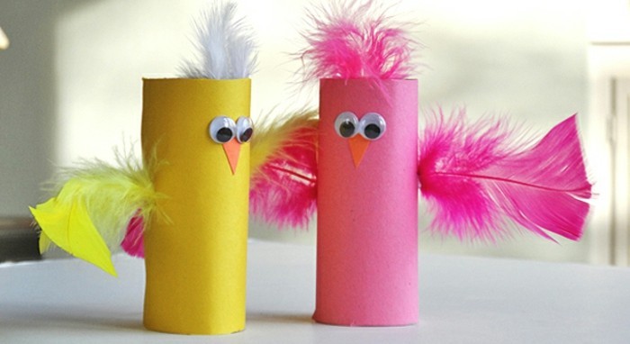 diy art projects, two toilet rolls dyed in pink and yellow, decorated with feathers to look like chicken, stick-on googly eyes