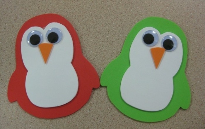 diys for your room, two penguins made from red and green felt, decorated with white nd orange felt details, and stick on eyes