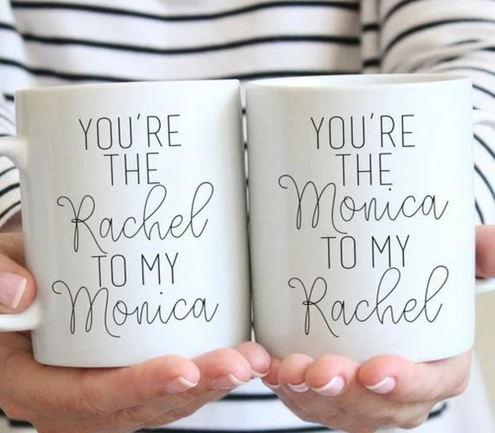 what to get your best friend for her birthday, close up of female hands, holding two white mugs with black writing