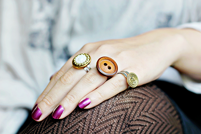 woamn's hand, with shiny purple nail polish, easy arts and crafts, three rings, made from clothes buttons