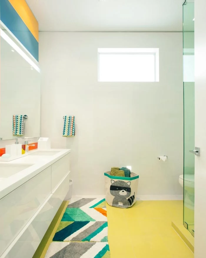 bathroom remodeling, spacious bathroom with large, white double sink, pastel yellow floor, four multicolored rugs, large mirror and blue and yellow stripes on wall above