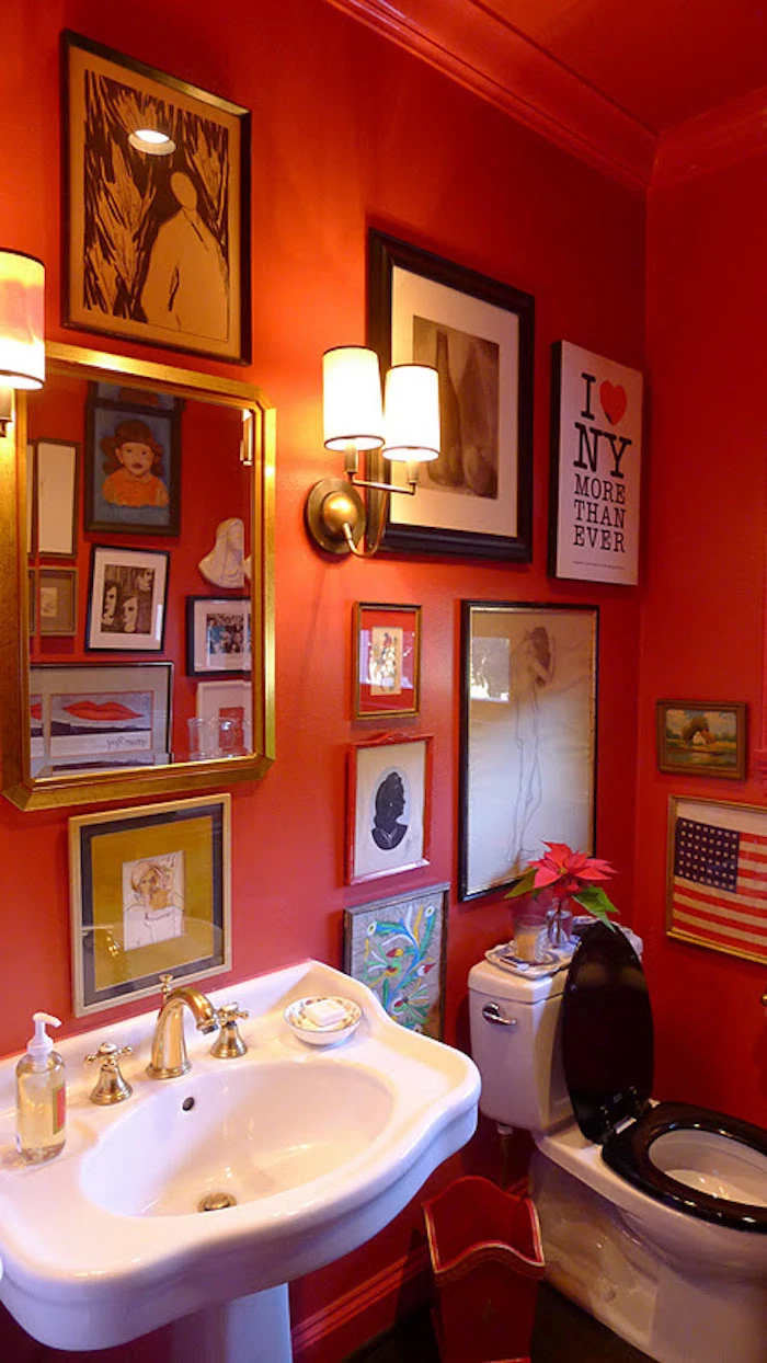 bathroom remodeling, bathroom with vintage black and white toilet, and white antique sink, with red walls decorated with many framed images, wall lights and a red ceiling