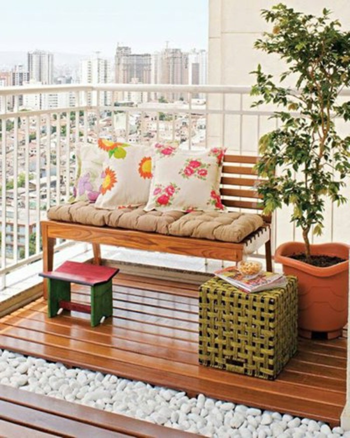 bench-made-of-wood-with-beige-cover-and-three-white-pillows-with-floral-pattern-near-large-potted-plant-bamboo-table-and-small-pink-and-green-wooden-chair-front-porch-decorating-ideas wooden bench with beige cover, and three floral cushions, porch ideas, wooden floor with white pebbles underneath, potted plant and small chair