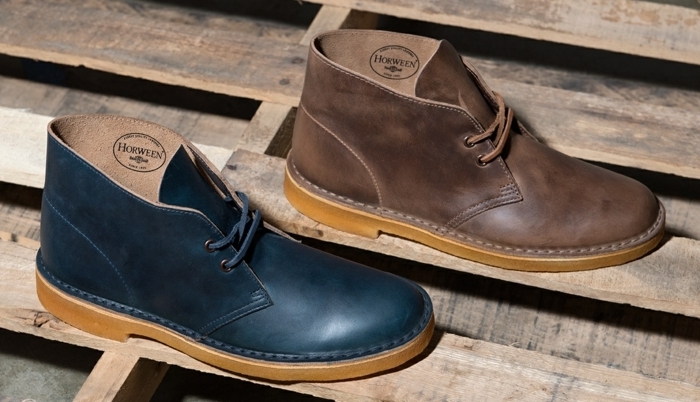 business casual shoes, two shoes in black and brown, with orange soles and laces, placed on wooden boards