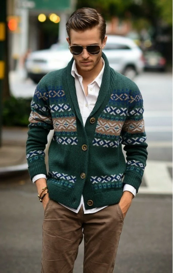 patterned green chunky knitted cardigan, worn over white shirt, and beige pants, business casual dress code, on young man with sunglasses