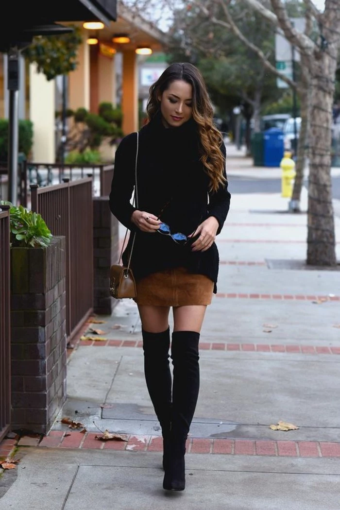 casual dress code, woman with brown and blonde ombre hair, wearing black turtleneck sweater, over beige suede mini skirt, with black over the knee boots, and small brown shoulder bag