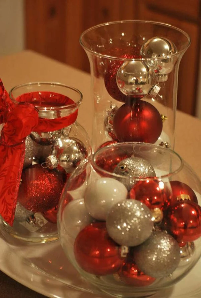mason jar decorations, glass containers filled with red, silver and white Christmas baubles, some covered in glitter