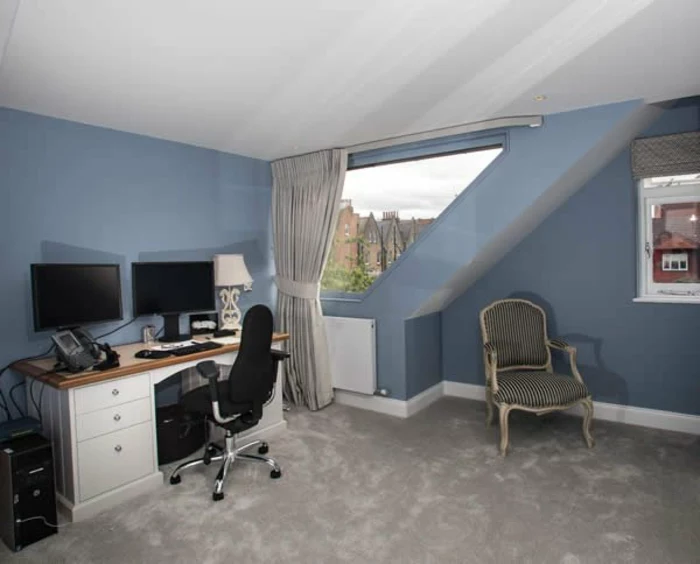 curtains ideas, attic office with blue walls, white and brown desk and black chair, two desktop computers, vintage chair and asymmetric window, with pale grey curtain