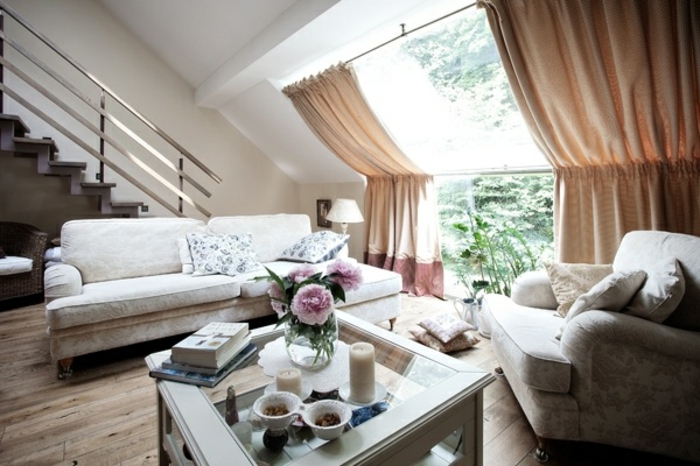 curtains-for-living-room-cream-sofa-and-settee-white-glass-top-table-with-decorations-big-sloping-window-with-pale-orange-curtains-wooden-floor-staircase curtains for living room, light patterned sofa and settee, white glass-top table, wooden floor and staircase, big sloped window, with light brown curtains