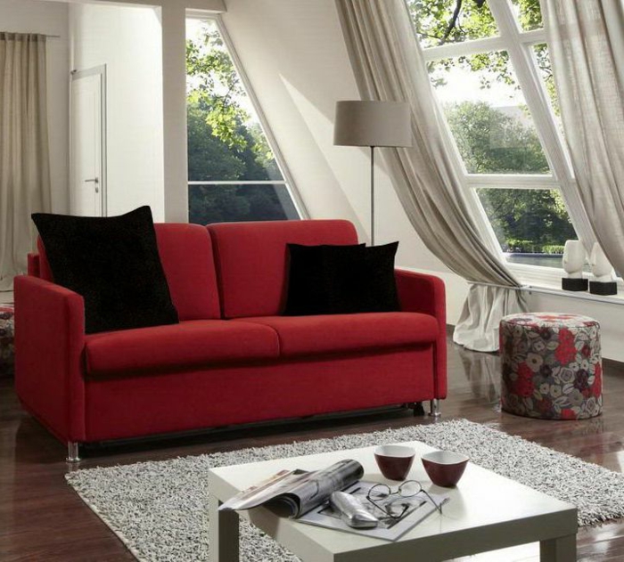curtains for living room, red sofa with black cushions, small white table, several windows some with pale cream curtains