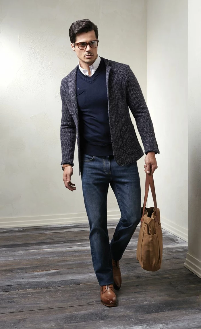 salt and pepper grey blazer, worn over navy v-neck jumper, and white shirt, with business casual jeans, on man with brown shoes, holding a bag in matching color