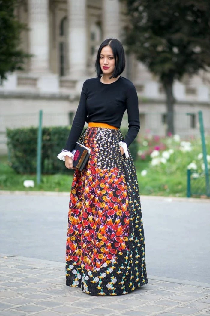 dress attire, black-haired woman with red lipstick, wearing plain black top, tucked into multicolored patterned maki skirt, with yellow belt
