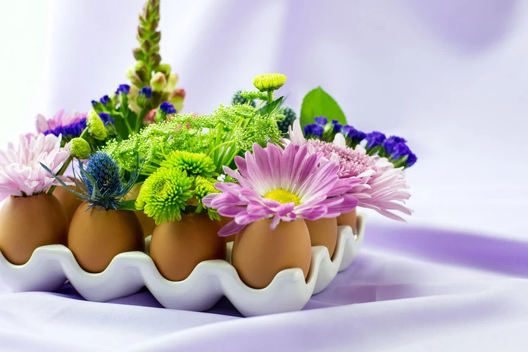eggs placed in white holder, fun and easy crafts, decorated with pale purple, green and blue flowers