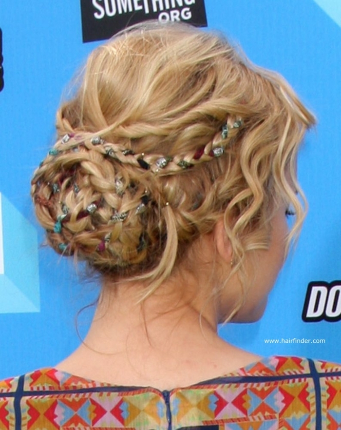 middle age hairstyles, blonde hair with twists and braids, shaped in a bun, with differently colored ribbons woven into it, worn by woman in a patterned top