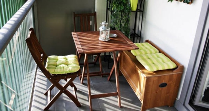 two wooden chairs with table and settee, pale green striped cushions, porch ideas, shelves with plants in background