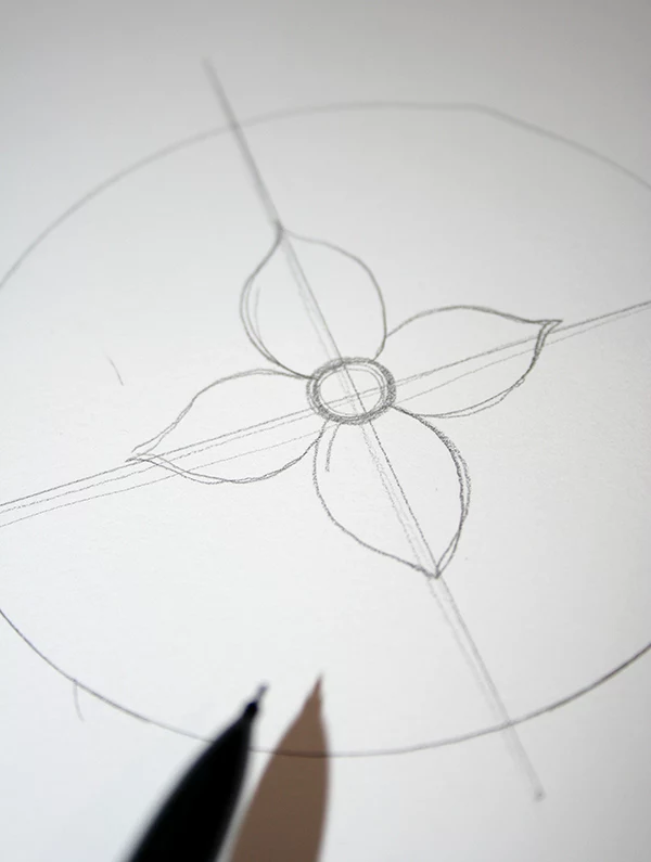 craft ideas, circle drawn in pencil on white piece of paper, with two crossing lines, and a flower in the middle