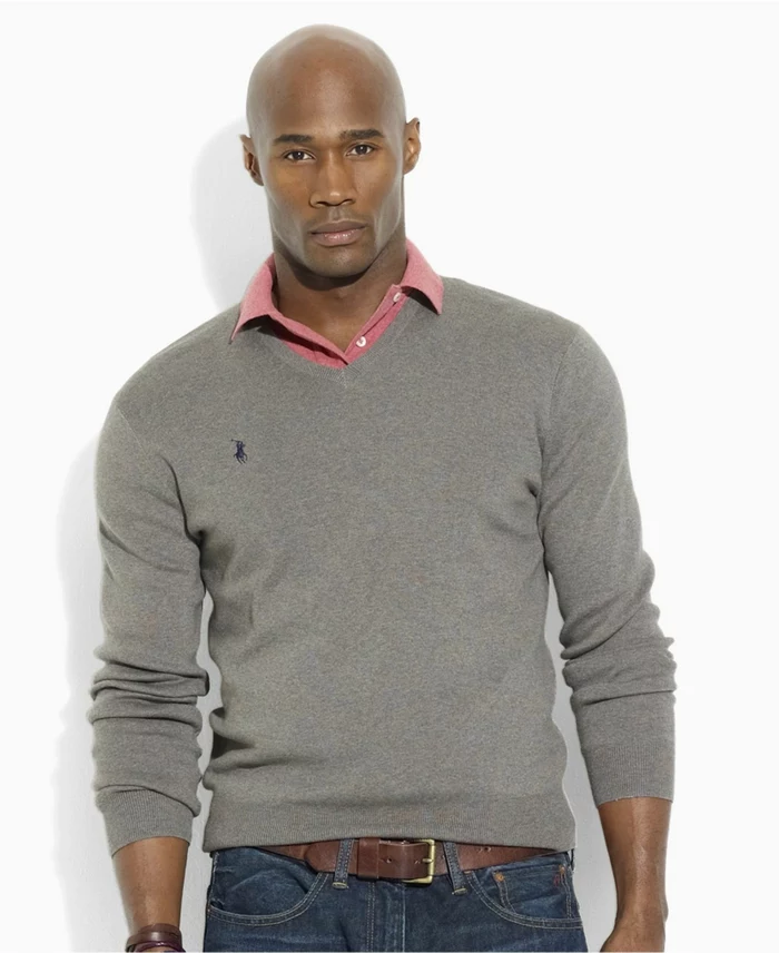 atheltic bald man, in business casual attire, with grey polo jumper, worn over pink shirt, and dark jeans, featuring a brown leather belt