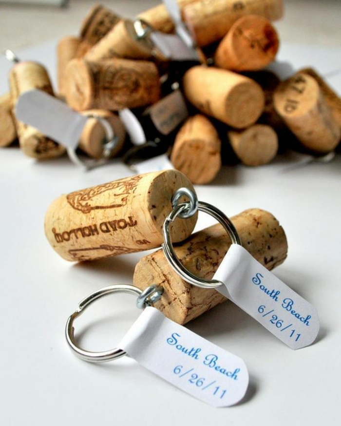 many keychains, made from cork bottle stoppers, and metal rings, decorated with white labels, marking a special ocassion, diy craft projects