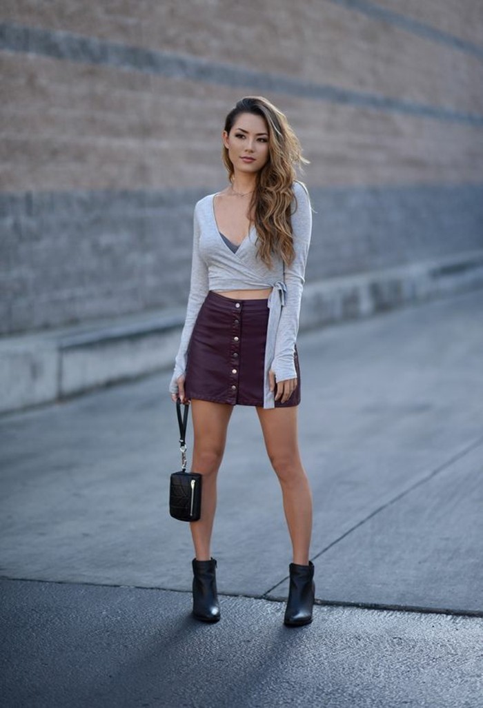 casual dress code, pale grey long sleeved top, purple leather button up skirt, and black ankle boots, worn by woman with blonde wavy hair