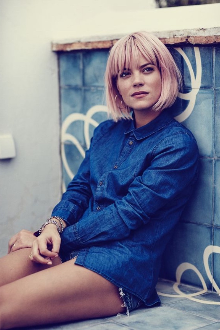 lily allen sporting pastel pink, short bob with bangs, in a dark denim shirt and shorts