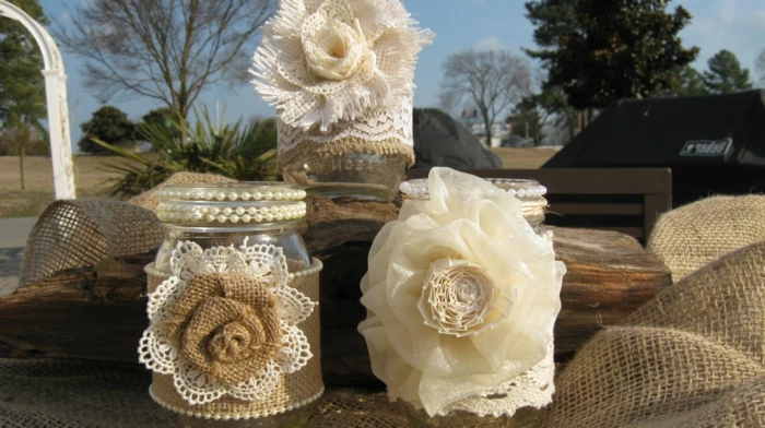mason jar gifts, three stacked small jars in beige, cream and white, decorated with pearls and lace, with burlap and silk flowers