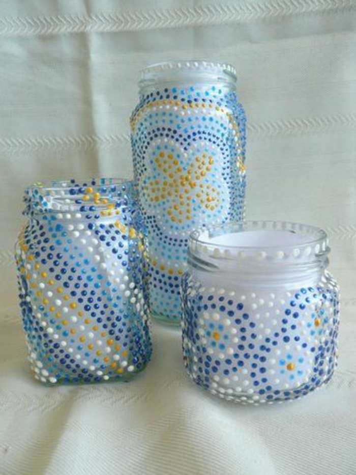 mason jar centerpieces, three jars decorated with small dots of color, forming different patterns, in pale and dark blue, white and yellow, 
