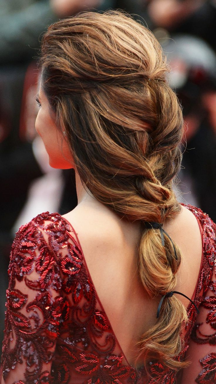 renaissance braids, dark honey blond hair, woven in a messy braid, tied with black ribbons, worn by slim woman, in red open-back embroidered dress