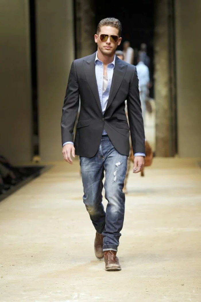 business casual dress code, male catwalk model, with distressed jeans, pale blue shirt, and black blazer, wearing sunglasses and worn, brown leather shoes