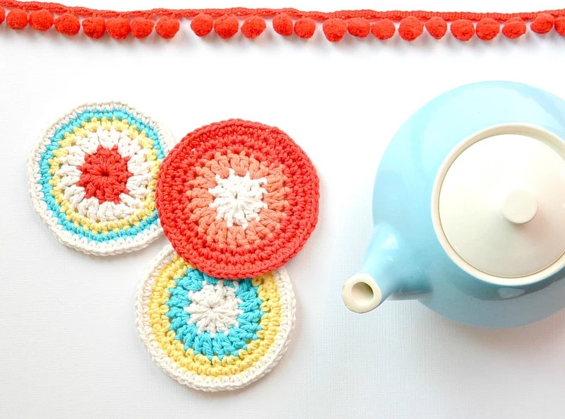 knitted coasters in red and white, white blue yellow and red, easy arts and crafts, near light blue and white teapot