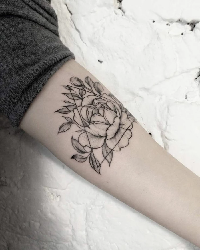flower tattoo designs, close up of a person's arm, rolled up grey sleeve, rose tattoo decorated with triangular shape, all outlined in black ink