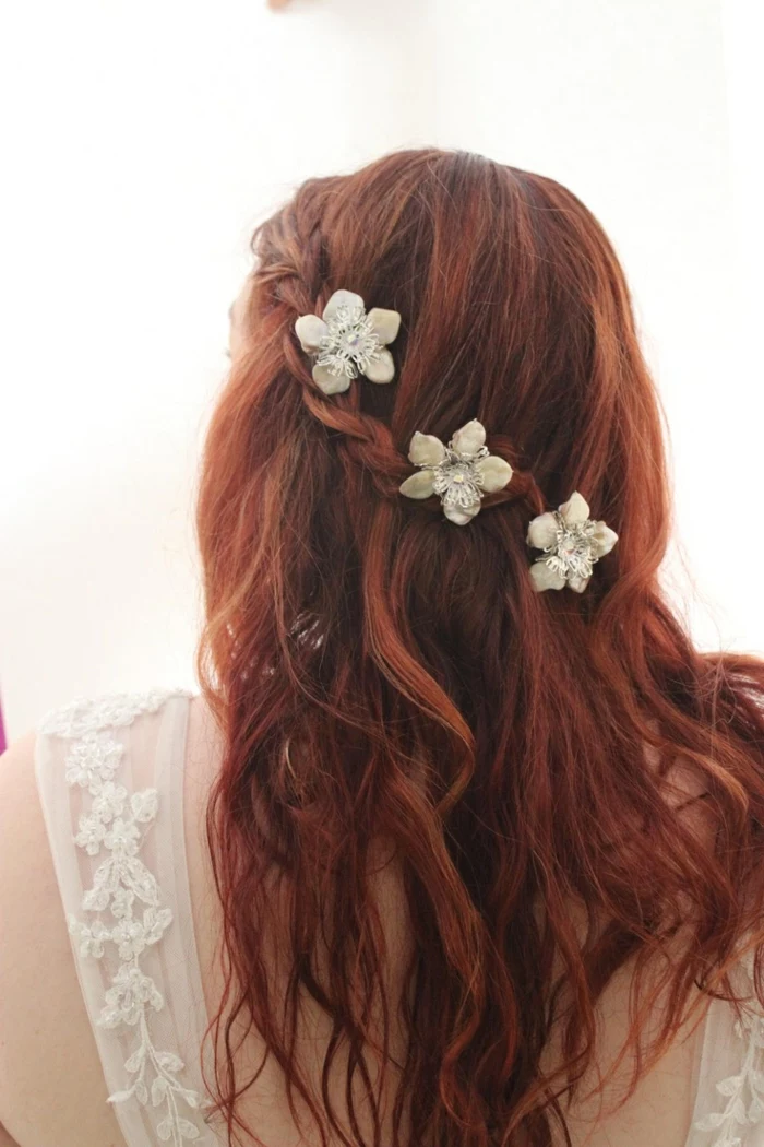 renaissance braids, messy and wavy red hair, with a single side braid, decorated with three white flower ornaments
