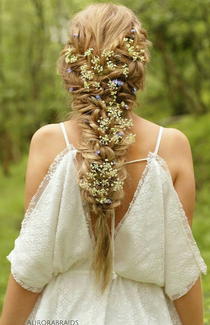 renaissance braids, long blonde messy braid, decorated with lots of tiny white and blue flowers, worn by woman in white off-shoulder lace dress
