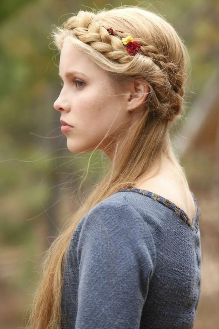 renaissance hairstyles, woman looking to one side, blue-grey rough fabric top, long straight blonde hair, woven into a crown-like braid, and decorated with flowers