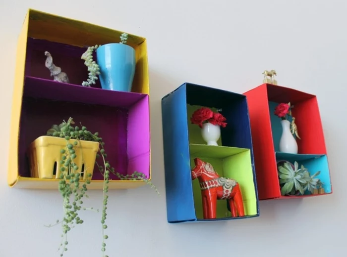 shelves made from carboard boxes, each painted in two different colors, yellow and purple, blue and green, or red and turquoise, homemade crafts
