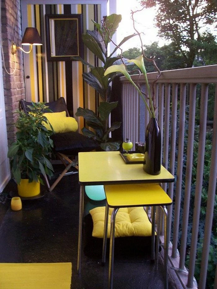 tiny square yellow table, with matching chair underneath, black lounging chair with yellow cushion, porch ideas, grey white black and yellow wallpaper