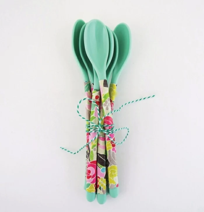 several turquoise colored spoons, fun and easy crafts, handles decorated with decoupage, tied together with blue and whte twisted string