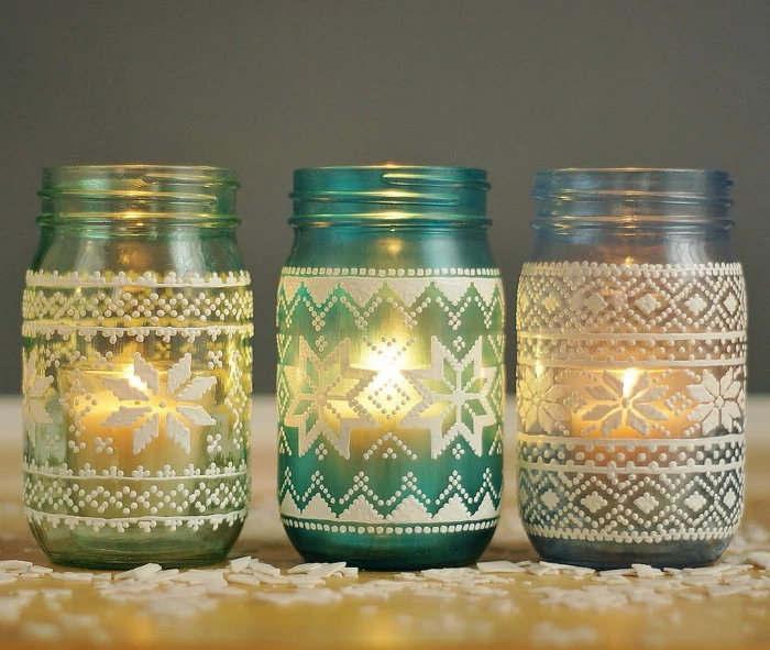 mason jar gifts, three jars in pale green, turquoise and blue, decorated with nordic sweater patterns, painted in white, and lit from within