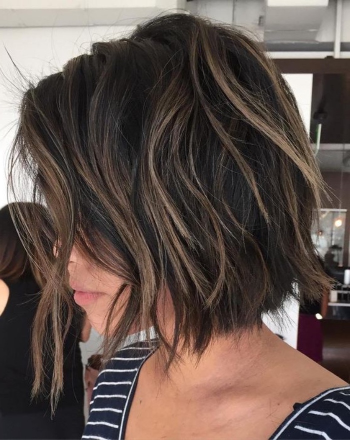 messy and wavy dark brunette hair, with dark blond highlights, short bob haircuts, worn by woman in striped top