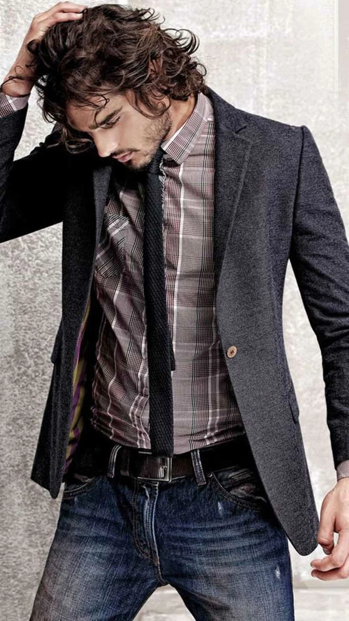 business casual men, curly-haired brunette man, dressed in grey blazer, plaid shirt with black tie, and dark denim jeans
