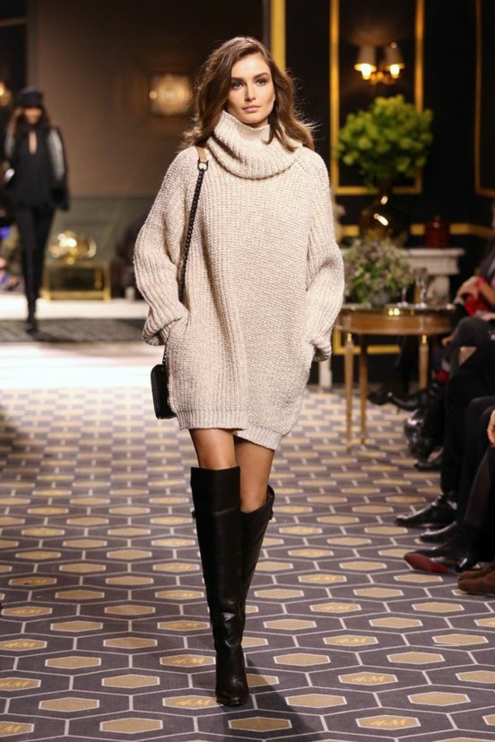 cute work outfits, oversized pale beige chunky knit turtleneck jumper dress, worn by brunette model, with dark knee-high boots, and small shoulder bag