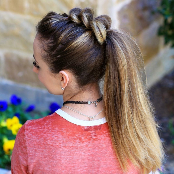 brown and blonde ombre hair, tied in high ponytail, with several braided segments, worn by woman in pink top
